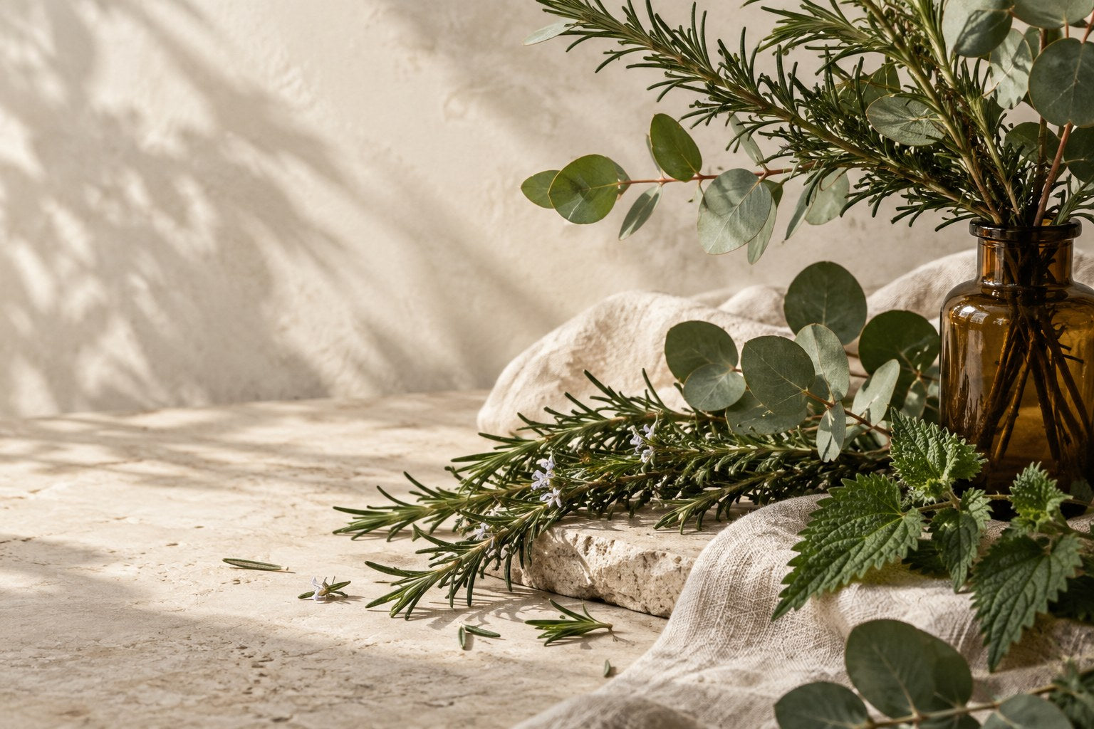 Botanical stems, amber glass and natural linen in soft daylight